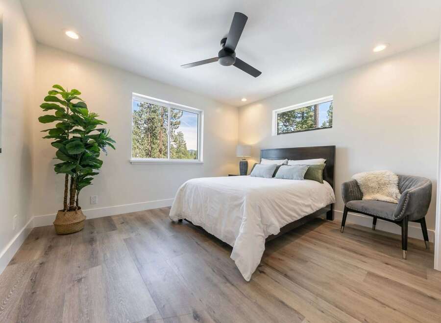Experience serene living in this beautifully appointed bedroom, featuring a comfortable queen-size bed dressed in crisp white linens.