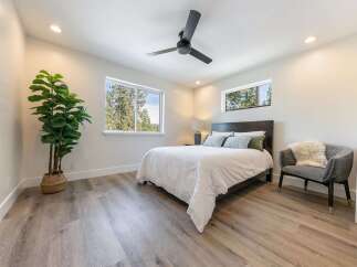 Experience serene living in this beautifully appointed bedroom, featuring a comfortable queen-size bed dressed in crisp white linens.