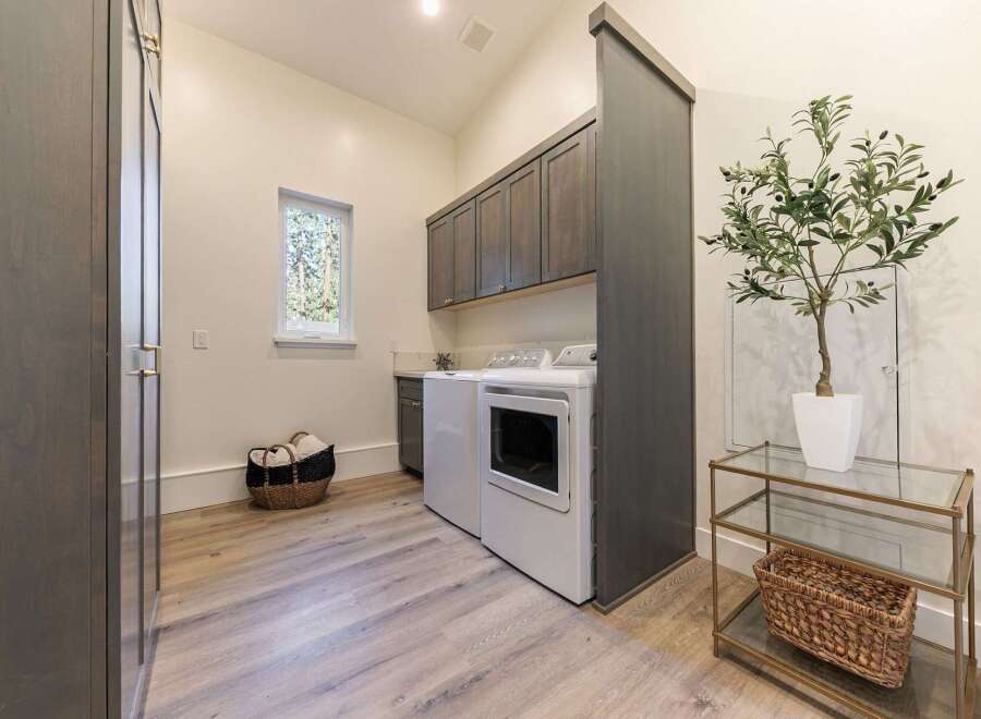 Discover this beautifully appointed laundry room, featuring a stacked washer and dryer for space efficiency.