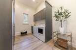 Discover this beautifully appointed laundry room, featuring a stacked washer and dryer for space efficiency.