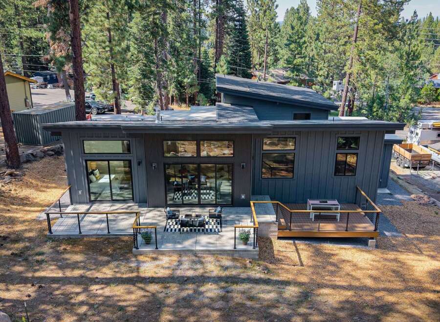 Experience modern living in this stunning contemporary home, featuring sleek dark siding and a unique asymmetrical roofline.