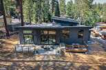 Experience modern living in this stunning contemporary home, featuring sleek dark siding and a unique asymmetrical roofline.