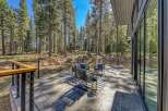 Experience seamless indoor-outdoor living with this stunning patio, nestled amongst towering pine trees.