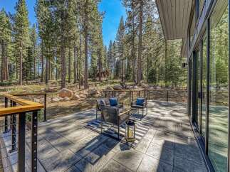 Experience seamless indoor-outdoor living with this stunning patio, nestled amongst towering pine trees.