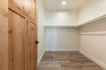 Step into this spacious walk-in closet, featuring a convenient built-in shelving system perfect for organizing your wardrobe.