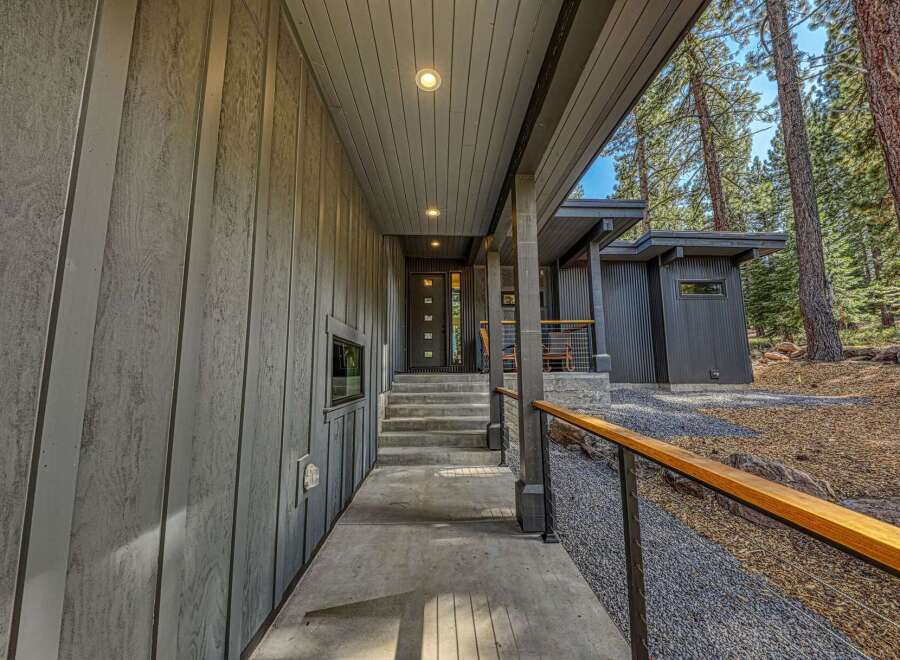 Experience modern mountain living with this stunning home featuring sleek vertical siding and a covered entryway.