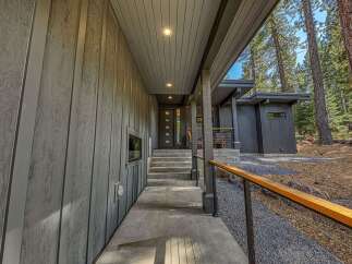 Experience modern mountain living with this stunning home featuring sleek vertical siding and a covered entryway.