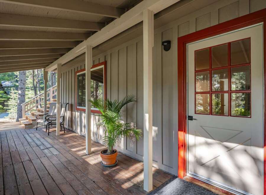 Step onto the charming wooden porch of this inviting home, perfect for enjoying the surrounding natural beauty.