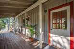 Step onto the charming wooden porch of this inviting home, perfect for enjoying the surrounding natural beauty.