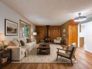 Experience cozy living in this inviting living room, featuring a striking wood-paneled accent wall and a modern wood-burning stove.