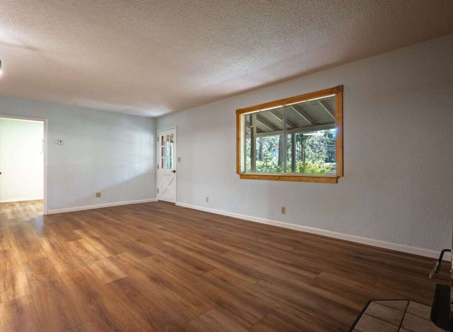 Step into this inviting living space featuring a bright and airy atmosphere, complemented by beautiful wood-look flooring that flows throughout the room.