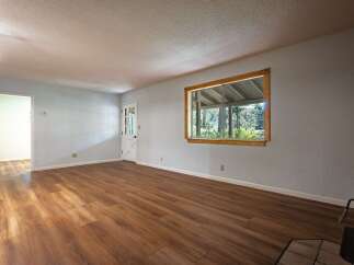 Step into this inviting living space featuring a bright and airy atmosphere, complemented by beautiful wood-look flooring that flows throughout the room.