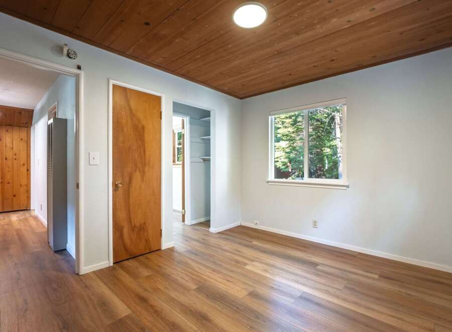 Step into this charming room featuring a warm wooden ceiling and durable laminate flooring.