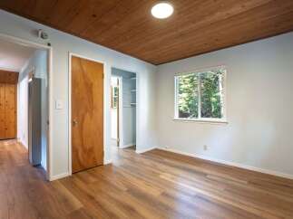 Step into this charming room featuring a warm wooden ceiling and durable laminate flooring.