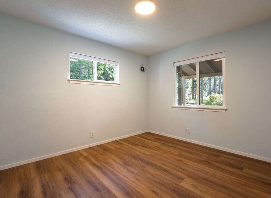 This empty room features light blue walls and warm wood-look flooring, creating a neutral and inviting space.