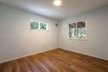 This empty room features light blue walls and warm wood-look flooring, creating a neutral and inviting space.