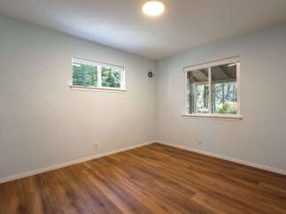 This empty room features light blue walls and warm wood-look flooring, creating a neutral and inviting space.