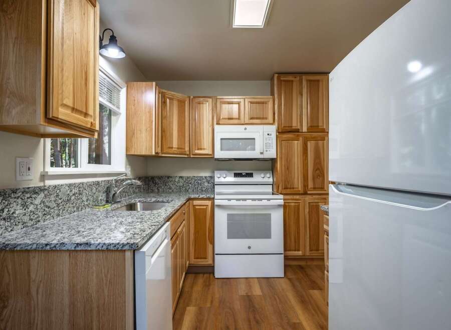 Discover this charming kitchen featuring warm wood cabinetry and sleek granite countertops.