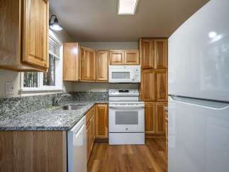 Discover this charming kitchen featuring warm wood cabinetry and sleek granite countertops.