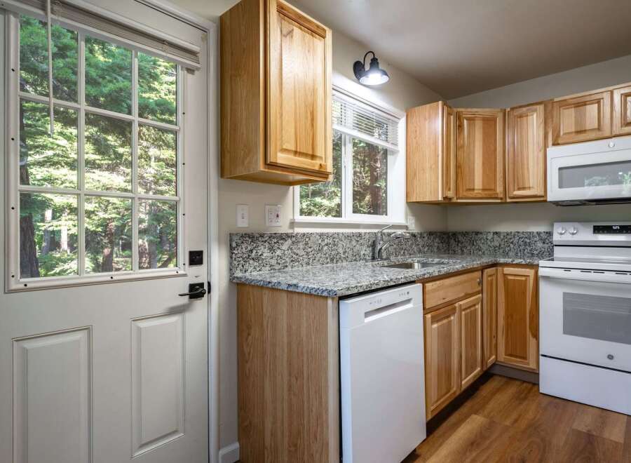 Step into this charming kitchen featuring light wood cabinetry and granite countertops.