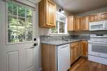 Step into this charming kitchen featuring light wood cabinetry and granite countertops.