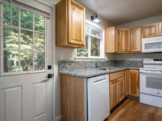 Step into this charming kitchen featuring light wood cabinetry and granite countertops.
