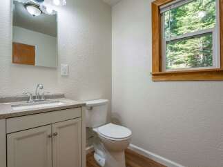 This charming bathroom features a modern vanity with a granite countertop and a sleek chrome faucet, complemented by a white toilet.