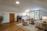 Discover this charming attic studio featuring a functional kitchenette with ample cabinet space and a full-sized stove.