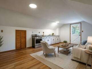 Discover this charming attic studio featuring a functional kitchenette with ample cabinet space and a full-sized stove.