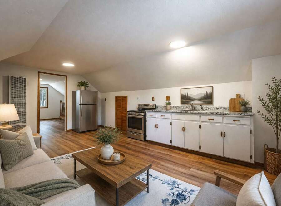 Discover this charming studio apartment featuring a compact kitchen with white cabinetry and granite countertops, perfect for preparing meals.