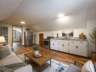 Discover this charming studio apartment featuring a compact kitchen with white cabinetry and granite countertops, perfect for preparing meals.