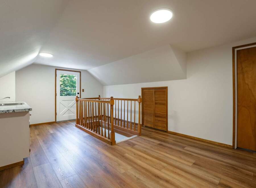 Discover this charming attic space featuring a convenient kitchenette with a sink and granite countertops.