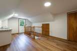 Discover this charming attic space featuring a convenient kitchenette with a sink and granite countertops.
