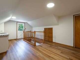 Discover this charming attic space featuring a convenient kitchenette with a sink and granite countertops.