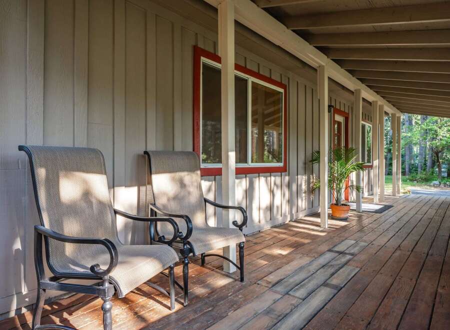 Enjoy the serene outdoors from this charming covered porch, perfect for relaxing with a morning coffee or evening drink.
