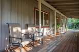 Enjoy the serene outdoors from this charming covered porch, perfect for relaxing with a morning coffee or evening drink.