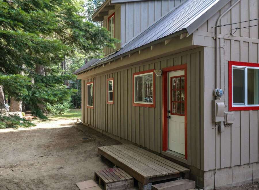 Discover this charming cabin nestled among tall trees, offering a rustic retreat.