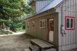 Discover this charming cabin nestled among tall trees, offering a rustic retreat.