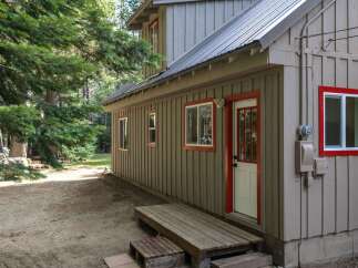 Discover this charming cabin nestled among tall trees, offering a rustic retreat.