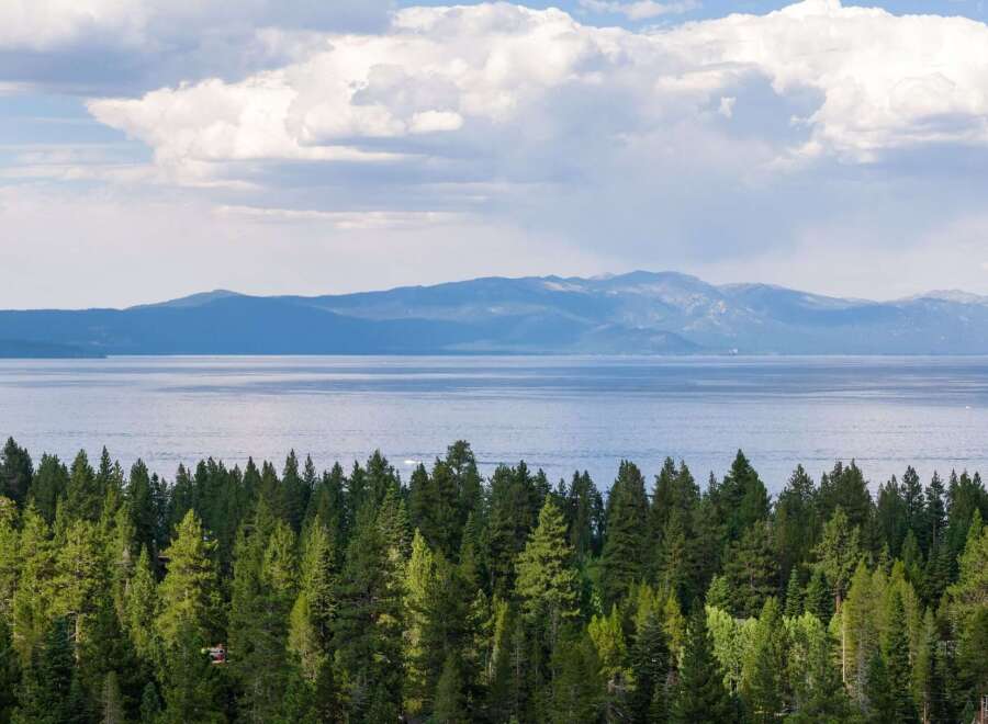 Experience breathtaking lake and mountain views from this stunning property, nestled amidst a lush evergreen forest.