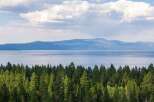 Experience breathtaking lake and mountain views from this stunning property, nestled amidst a lush evergreen forest.