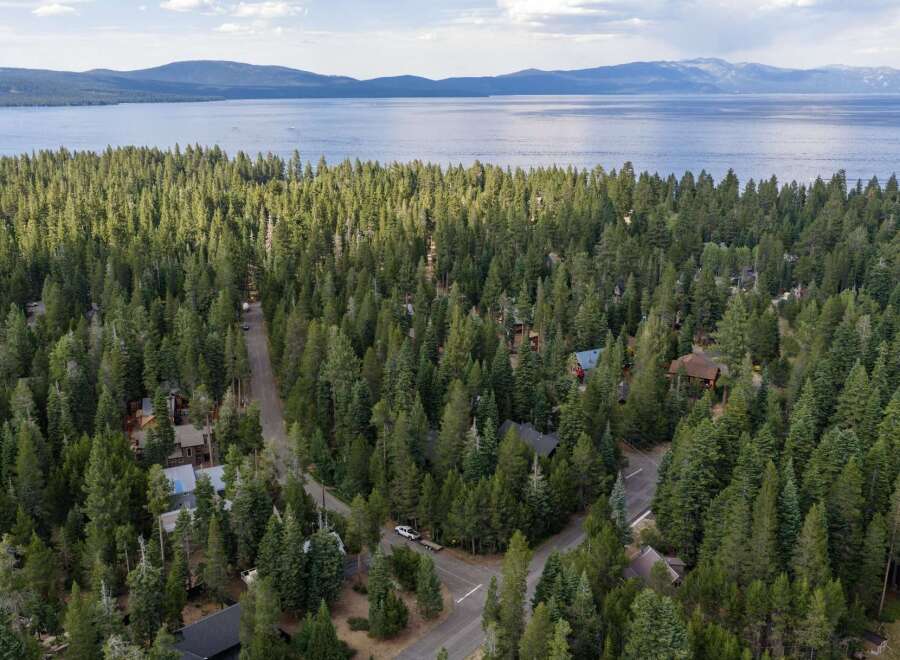 Nestled within a dense forest of mature pine trees, this property offers a secluded retreat with stunning lake views in the distance.