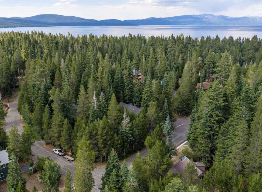 Nestled within a dense pine forest, this property offers a serene retreat with stunning views of a distant lake and mountains.