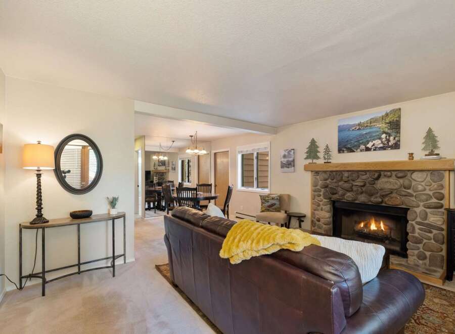 Cozy living room featuring a stone fireplace with a roaring fire, perfect for chilly evenings.
