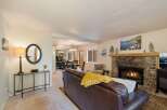 Cozy living room featuring a stone fireplace with a roaring fire, perfect for chilly evenings.