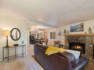 Cozy living room featuring a stone fireplace with a roaring fire, perfect for chilly evenings.