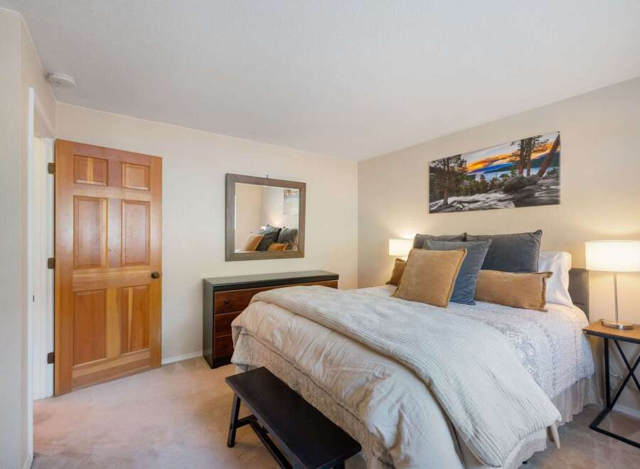 Step into this inviting bedroom, featuring a comfortable queen-size bed adorned with plush pillows and a cozy duvet.
