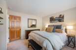 Step into this inviting bedroom, featuring a comfortable queen-size bed adorned with plush pillows and a cozy duvet.
