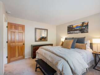Step into this inviting bedroom, featuring a comfortable queen-size bed adorned with plush pillows and a cozy duvet.