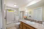 This bright and airy bathroom features a spacious vanity with a granite countertop and ample storage.